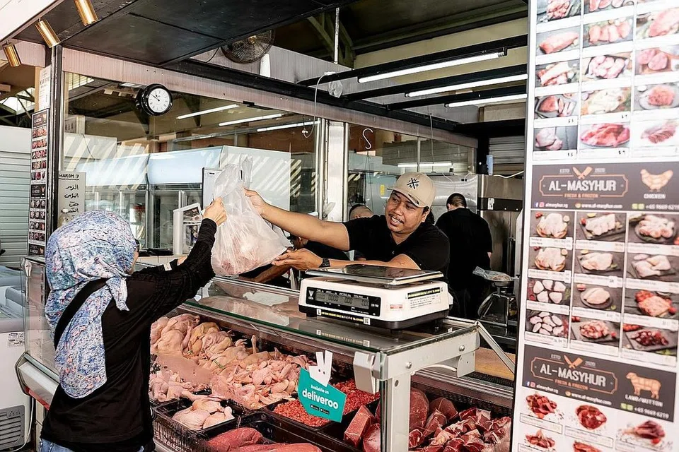 SUNTIK KESEGARAN PADA KONSEP PASAR BASAH: Encik Muhamad Hadhir (kanan) memilih lokasi di pasar basah Tampines Mart untuk membuka perniagaannya kerana berpendapat pelanggan lebih selesa berbelanja di sana. - Foto BM oleh NUR DIYANA TAHA