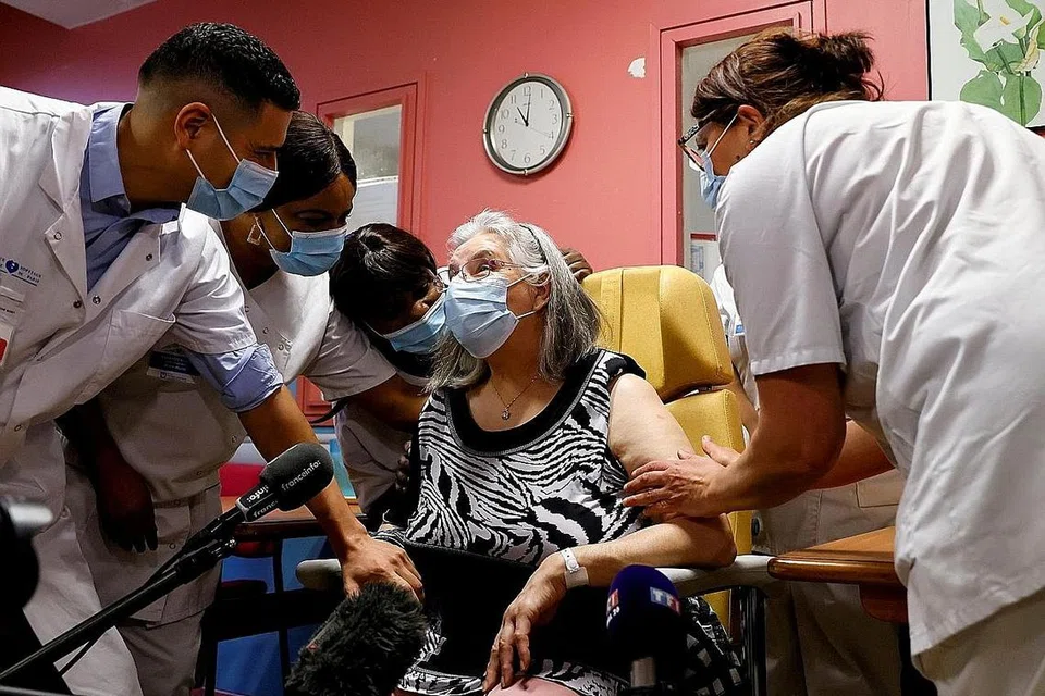 TERIMA SUNTIKAN: Pekerja kesihatan berbual dengan Cik Mauricette, seorang wanita Perancis berusia 78 tahun, setelah beliau menerima dos pertama vaksin Pfizer-BioNTech (COVID-19) di hospital Rene-Muret di Sevran, di pinggiran Paris, Perancis. - Foto REUTERS