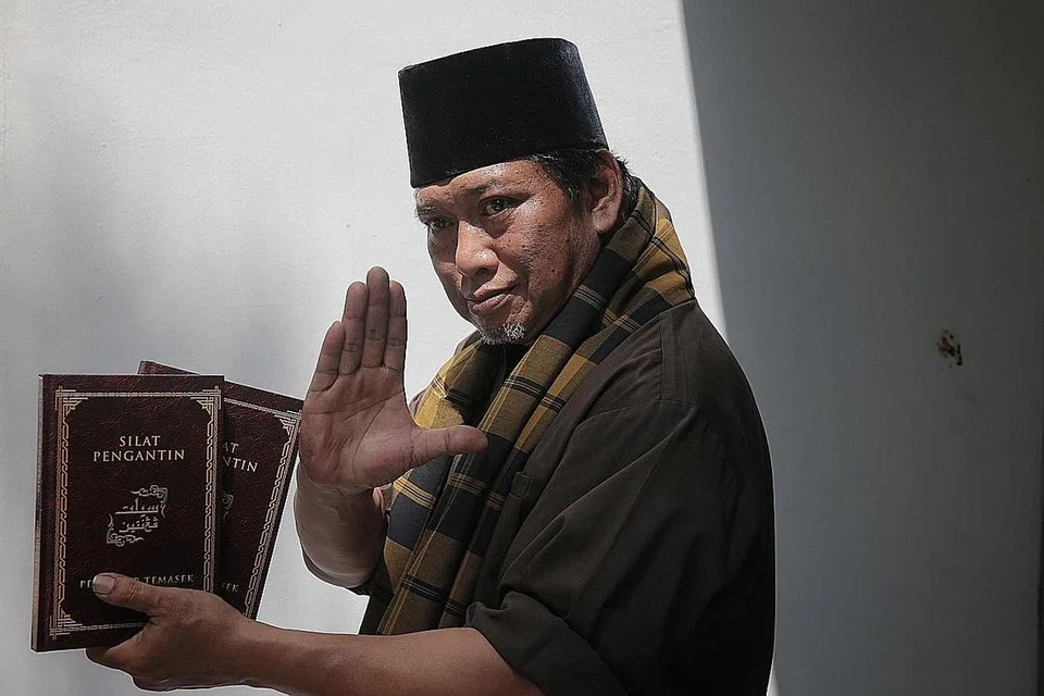 KONGSI TENTANG SILAT PENGANTIN: Guru dan penggiat silat, Encik Iskandar Muda Abdul Jalil Rais, berharap bukunya 'Silat Pengantin' akan menggalak orang ramai lebih mendalami ilmu silat. Silat bukan sekadar pertahanan diri, malah boleh mengajar orang ramai tentang pendidikan dan budaya. Beliau dirakam di rumahnya dalam kawasan Hougang kelmarin. - Foto BH oleh JASON QUAH