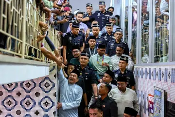 Perdana Menteri Malaysia, Datuk Seri Anwar Ibrahim (depan, kiri), sempat beramah-tamah dengan orang ramai ketika ke Masjid India, Kuala Lumpur, untuk menunaikan solat Jumaat bersama 5,000 anggota jemaah lain.