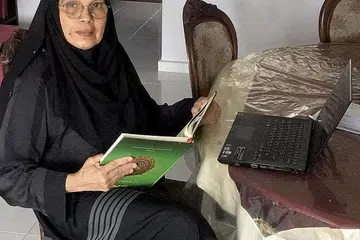 SEDIA SAHUT CABARAN: Meskipun sibuk menyenggarakan pembelajaran dalam talian kepada pelajarnya, Ustazah Bibi Sahidah Syed Attar Shah, 67 tahun, juga memandu Grab secara sambilan dan percaya kepada kepentingan untuk terus belajar kemahiran baru. - Foto ihsan BIBI SAHIDAH SYED ATTAR SHAH