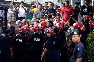 KEADAAN TEGANG: Polis menahan sekumpulan penunjuk perasaan yang membantah pelaksanaan cukai barangan dan perkhidmatan (GST) yang dijadualkan pada 1 April ini. - Foto THE MALAYSIAN INSIDER