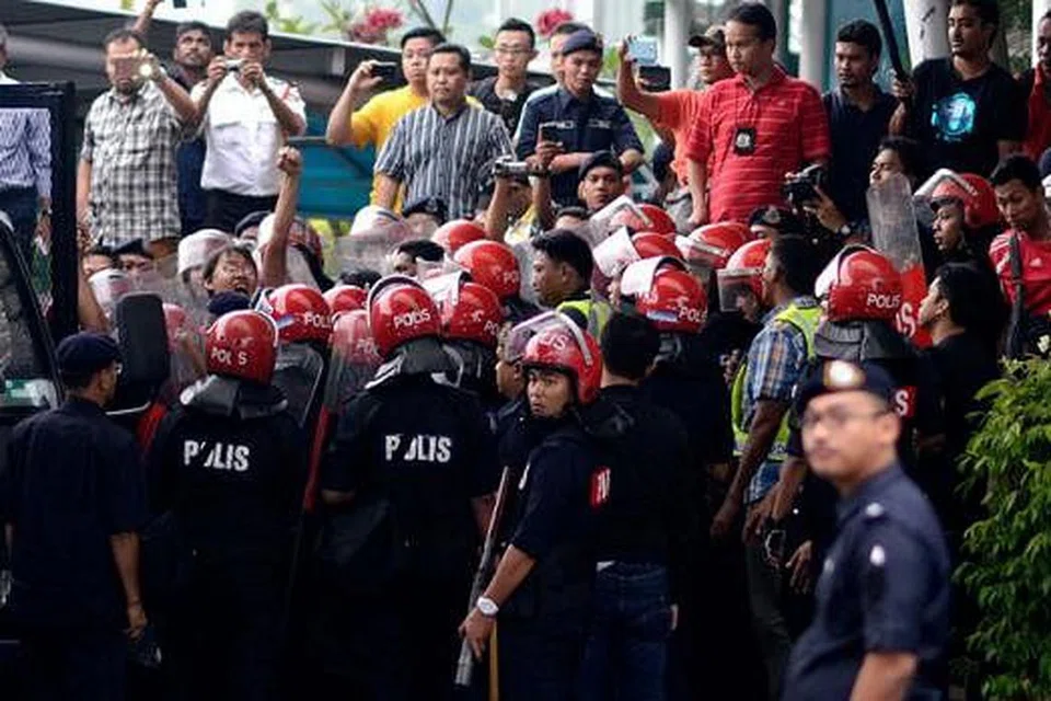 KEADAAN TEGANG: Polis menahan sekumpulan penunjuk perasaan yang membantah pelaksanaan cukai barangan dan perkhidmatan (GST) yang dijadualkan pada 1 April ini. - Foto THE MALAYSIAN INSIDER