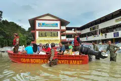 DILANDA BANJIR: Foto fail menunjukkan pegawai penyelamat memindahkan orang ramai dengan menggunakan bot di Shah Alam, Selangor, apabila banjir melanda Disember tahun lalu. Banjir dijangka lagi tahun ini apabila rakyat Malaysia keluar mengundi bulan depan. - Foto AFP