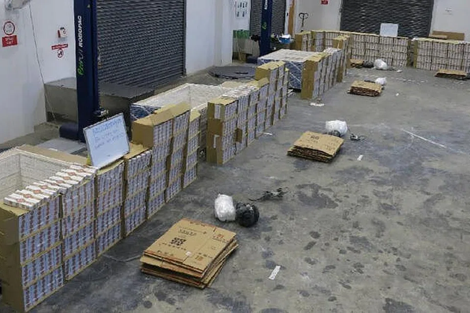 TEMPAT SIMPANAN: Karton rokok tidak dibayar cukai telah disembunyikan dan berjaya ditemui pegawai kastam di sebuah bangunan perindustrian kosong di Gul Circle.- Foto KASTAM SINGAPURA 