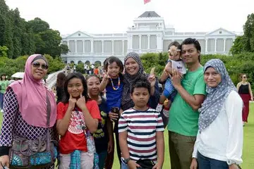 PERTAMA KALI DI ISTANA: Cik Izyani (lima dari kiri) bersama suami, anak, ibu mentua, kakak ipar, anak saudara dan pembantu rumah mereka seronok bersiar-siar di pekarangan Istana semalam. - Foto TUKIMAN WARJI