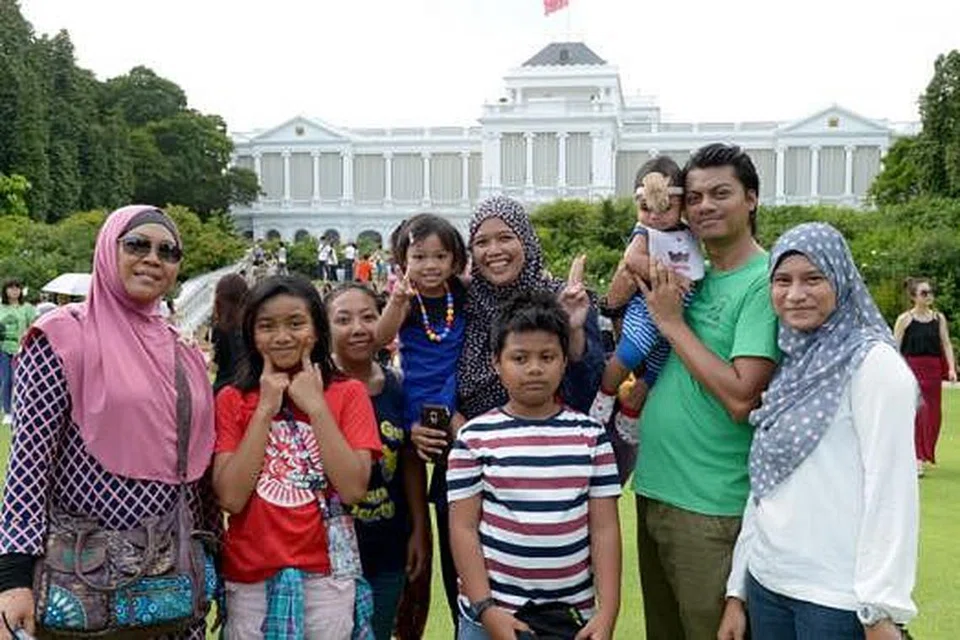 PERTAMA KALI DI ISTANA: Cik Izyani (lima dari kiri) bersama suami, anak, ibu mentua, kakak ipar, anak saudara dan pembantu rumah mereka seronok bersiar-siar di pekarangan Istana semalam. - Foto TUKIMAN WARJI