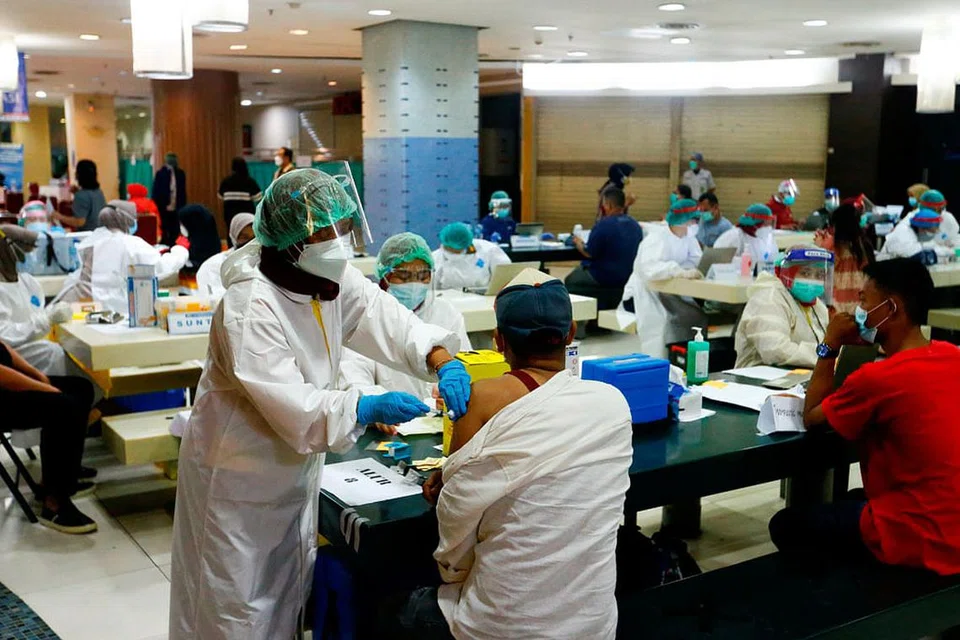 SUNTIKAN VAKSIN DI PASAR TEKSTIL: Seorang peniaga menerima vaksin Sinovac Biotech di pasar Tanah Abang, Jakarta, semalam. - Foto REUTERS