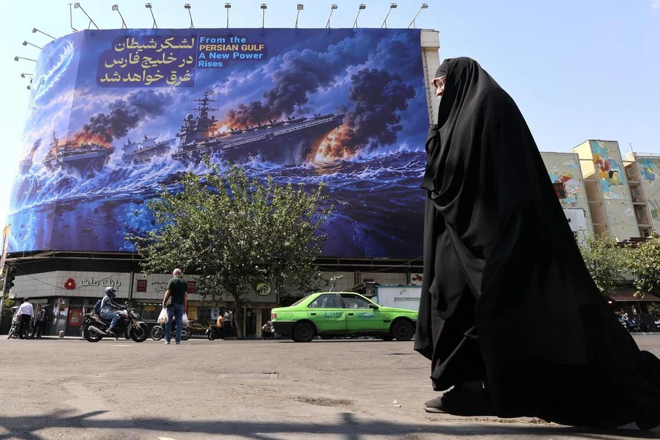 Penduduk Iran melintasi papan iklan besar anti-Amerika Syarikat yang antara lain membawa mesej bahawa tentera Amerika akan “ditenggelamkan di Teluk Parsi”, di Dataran Enghelab, Teheran, pada 14 September. Perang dengan Iran sudah menelan belanja kira-kira AS$38 bilion ($48 bilion) bagi tentera Amerika sehingga 1 Ogos, termasuk AS$21.7 bilion untuk menggantikan peluru dan senjata yang digunakan, menurut Pejabat Belanjawan Kongres (CBO).