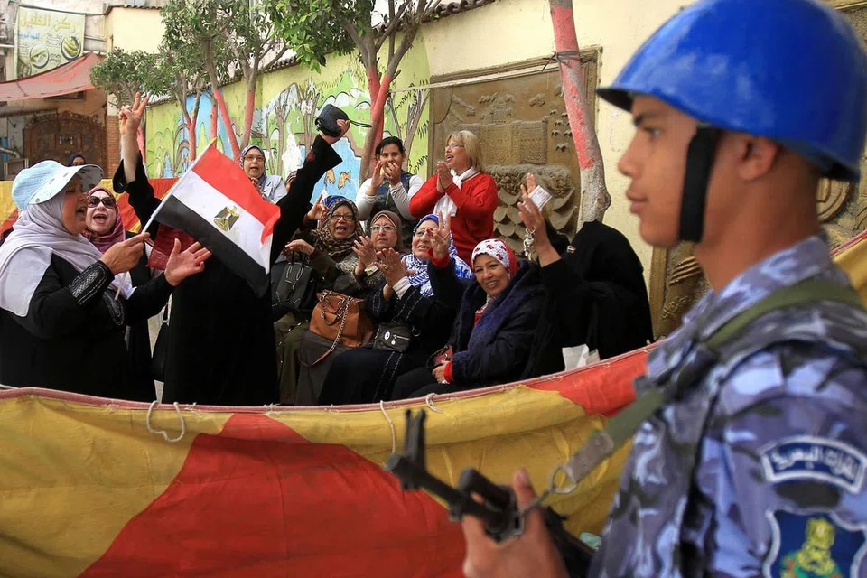 TUNJUK SOKONGAN: Wanita Mesir berhimpun di luar pusat mengundi di bandar Iskandariah pada hari pertama undian pilihan Presiden Mesir, kelmarin. - Foto AFP