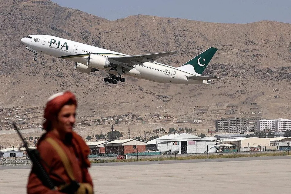 KEMBALI BEROPERASI: Seorang askar Taleban membuat kawalan sedang pesawat komersial milik Pakistan berlepas dari lapangan terbang antarabangsa Kabul pada 13 September. Pemerintah Taleban berkata lapangan terbang itu kini boleh digunakan semula. - Foto AFP
