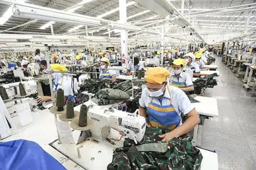 MANFAATKAN INDUSTRI TEKNOLOGI 4.0: Para pekerja di sebuah kilang Indonesia menjahit pakaian tentera di Sukoharjo, Jawa Tengah. Syarikat kilang itu memanfaatkan industri teknologi 4.0, termasuk automasi dan 'Internet of Things' untuk menyokong pengeluarannya. - Foto SRI REZEKI ISMAN (SRITEX)