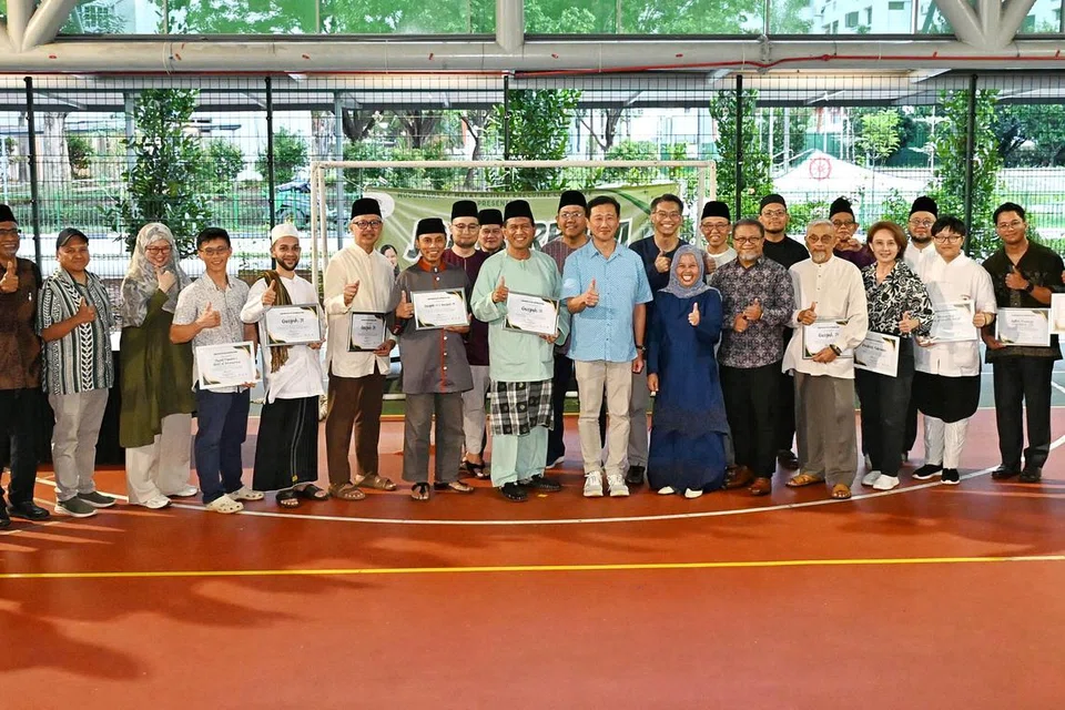 Encik Ong Ye Kung (berbaju biru di tengah), Cik Mariam Jaafar (bertudung biru di tengah) dan Encik Zalman Putra Ahmad Ali (sebelah Cik Mariam) bersama para penderma Kempen Amal Ramadan ‘Spirit of Sembawang’ M³@Woodlands.