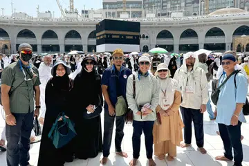 Dr Mohamad Maliki Osman (empat dari kanan), dan isterinya, Cik Sadiah Shahal (di sebelahnya), bergambar bersama Pejabat Ehwal Jemaah Haji Singapura (SPAO) Muis sebelum menunaikan tawaf wada (tawaf selamat tinggal sebelum pulang) pada 20 Jun.      