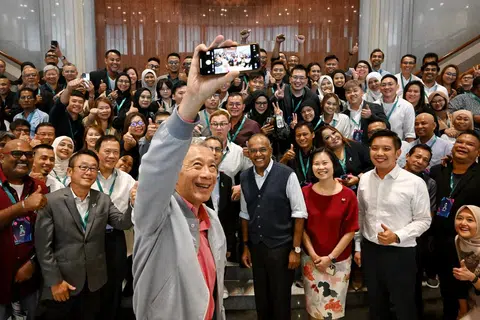 Perdana Menteri, Encik Lee Hsien Loong, mengambil swafoto bersama 120 bekas pesalah dadah dan ahli keluarga mereka di Parlimen, bersama Menteri Ehwal Dalam Negeri merangkap Undang-Undang, Encik K. Shanmugam (memakai ves hitam) dan Menteri Negara (Ehwal Dalam Negeri merangkap Pembangunan Negara), Profesor Madya Dr Muhammad Faishal Ibrahim (di kanan Encik Shanmugam).