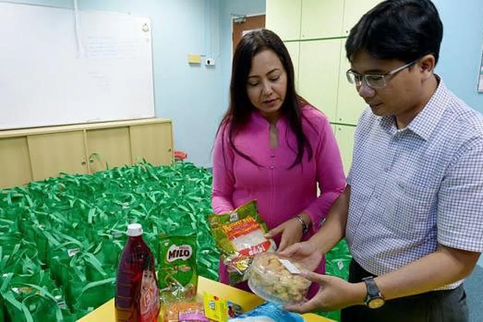 HULURKAN BANTUAN: Cik Razia dan Encik Rahmat bersama isi hamper makanan yang bakal diagihkan kepada 340 penerima habuan. - Foto TUKIMAN WARJI