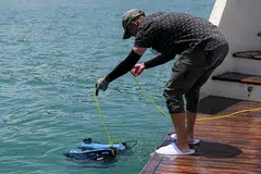 Penolong penyelidik Universiti Teknologi dan Reka Bentuk Singapura (SUTD), Encik Hoo Jun Jie, dari Makmal Visi dan Pembelajaran Robot Pelbagai Ejen (MARVL), keluarkan dron bawah air model BlueROV2 itu daripada kapal layar Star of the Sea di luar pantai Pulau Lazarus pada 11 Oktober 2024.