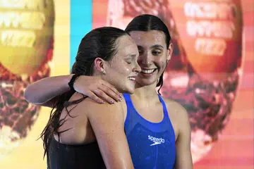 Pemenang pingat perak dari Israel, Anastasia Gorbenko (kiri) ditenangkan oleh Freya Constance Colbert dari Britain, ketika beliau diejek penonton selepas perlumbaan.