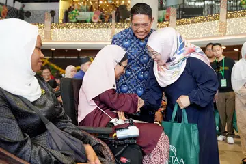 Menteri di Pejabat Perdana Menteri merangkap Menteri Kedua (Pendidikan dan Ehwal Luar), Dr Mohamad Maliki Osman, bersama isterinya, Cik Saadiah Sahal (kanan), menyampaikan sumbangan Kempen Dana Amal Tabung Amal Aidilfitri (TAA) kepada Cik Suhana Suhaimi (dua dari kiri) di acara pengagihan sumbangan yang berlangsung pada pagi 22 Mac di Persada Budaya, Wisma Geylang Serai.