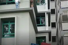 Seorang lelaki keluar dari tingkat unit lain dan berjalan perlahan-lahan untuk menyelamatkan budak kecil yang berdiri di luar tingkat sebuah flat. 