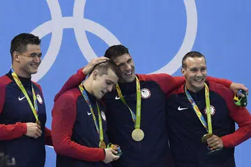 KEJAYAAN BERSEJARAH: Michael Phelps (tiga dari kiri) serta tiga rakan sepasukan (dari kiri) Nathan Adrian, Ryan Held dan Caeleb Dressel meraikan kejayaan merangkul emas perlumbaan 4x100m gaya bebas. - Foto-foto AFP