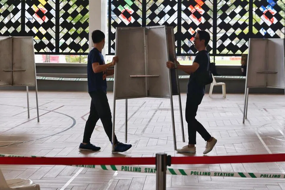 PERSIAPAN: Pegawai pilihan raya mengangkat dan meletakkan pondok mengundi di Pusat Mengundi yang terletak di Wisma Geylang Serai pada 31 Ogos 2023.
