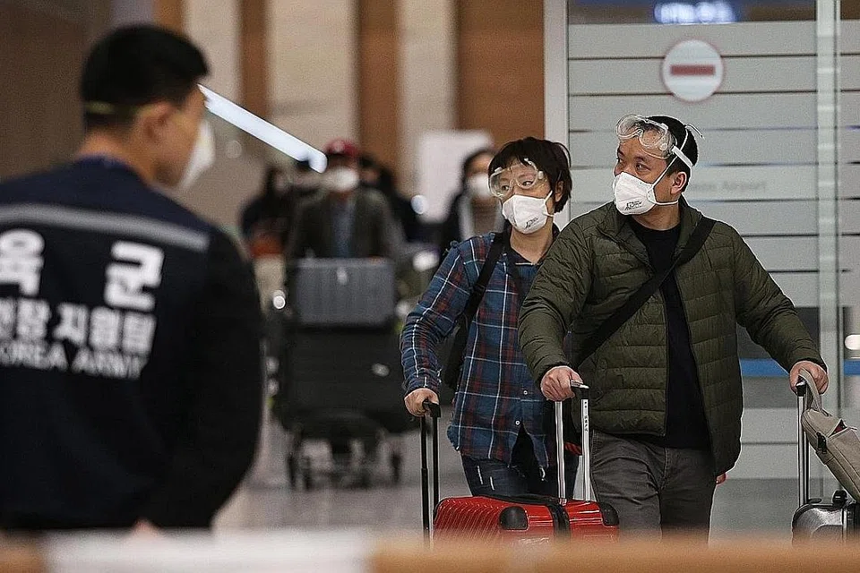 Penumpang asing yang menggunakan pelitup melalui pusat 'Open Walking-Thru' bagi menguji Covid-19 di lapangan terbang di Incheon, Korea Selatan. - Foto AFP, EPA-EFE