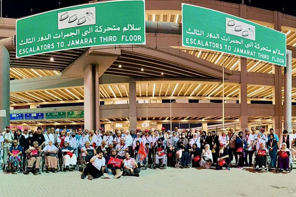 Jemaah Singapura bergambar dekat kawasan melontar jamrah di Mina, Arab Saudi.