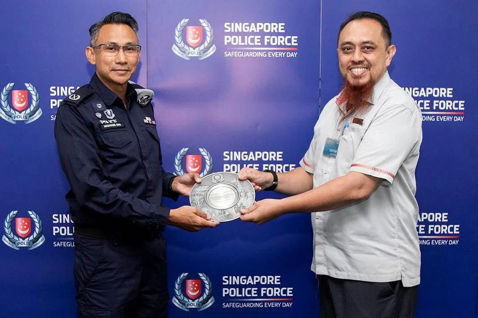 ANUGERAH: Encik Izhar Mohamed Ibrahim (kanan) terima Anugerah Kerjasama Masyarakat daripada Timbalan Penolong Pesuruhjaya (DAC) Masagoes Idris Hussain dalam majlis yang diadakan di Komand Keselamatan Pengangkutan Awam (TransCom). - Foto SPF