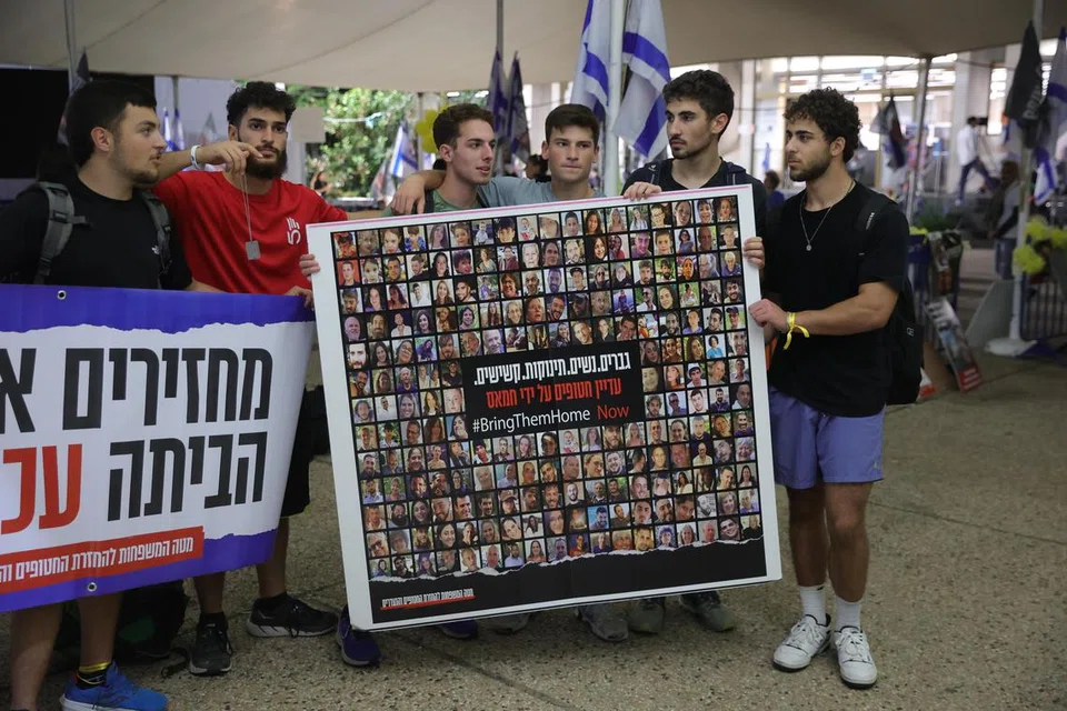 TUNTUT SEGERA BEBASKAN TEBUSAN: Sekumpulan lelaki memegang sepanduk yang memaparkan muka tebusan Israel yang ditahan Hamas dalam protes di luar Muzium Tel Aviv pada Rabu.