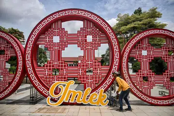 
Seorang pekerja majlis perbandaran memasang hiasan Tahun Baru Cina di hadapan Dewan Bandaraya sebagai persiapan untuk sambutan Tahun Baru Imlek di Surabaya pada 20 Januari.