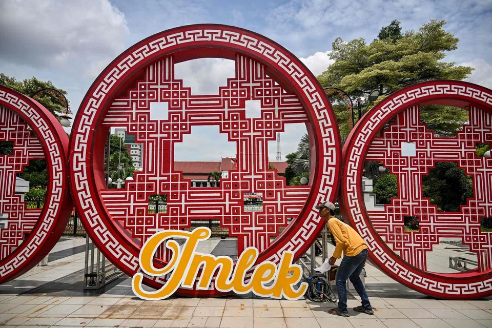 
Seorang pekerja majlis perbandaran memasang hiasan Tahun Baru Cina di hadapan Dewan Bandaraya sebagai persiapan untuk sambutan Tahun Baru Imlek di Surabaya pada 20 Januari.