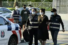 AKHIRNYA DIBERKAS: Pasangan yang dikatakan terlibat dalam kes penipuan barangan mewah berjumlah $32 juta ditangkap di Johor Bahru dan diserahkan kepada SPF untuk dibawa balik ke Singapura.