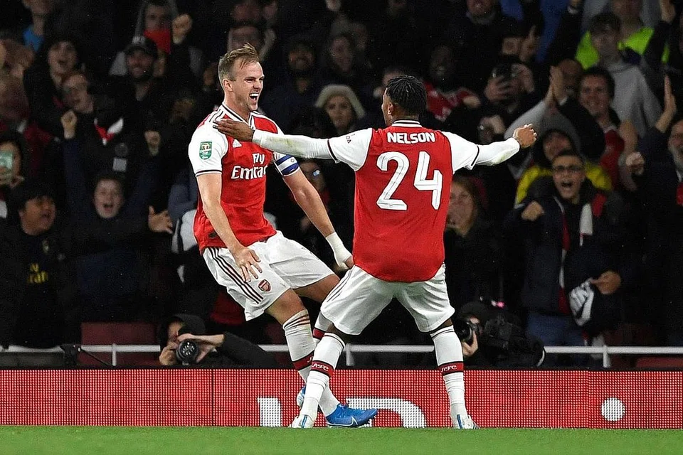 RAI KEMENANGAN: Pemain pertahanan Arsenal, Rob Holding, meraikan kejayaannya dengan rakan sepasukan, Reiss Nelson, setelah menjaringkan gol kedua pasukan semasa perlawanan menentang Nottingham Forest di Stadium Emirates, London, semalam. Arsenal membenam Nottingham Forest 5-0. - Foto REUTERS
