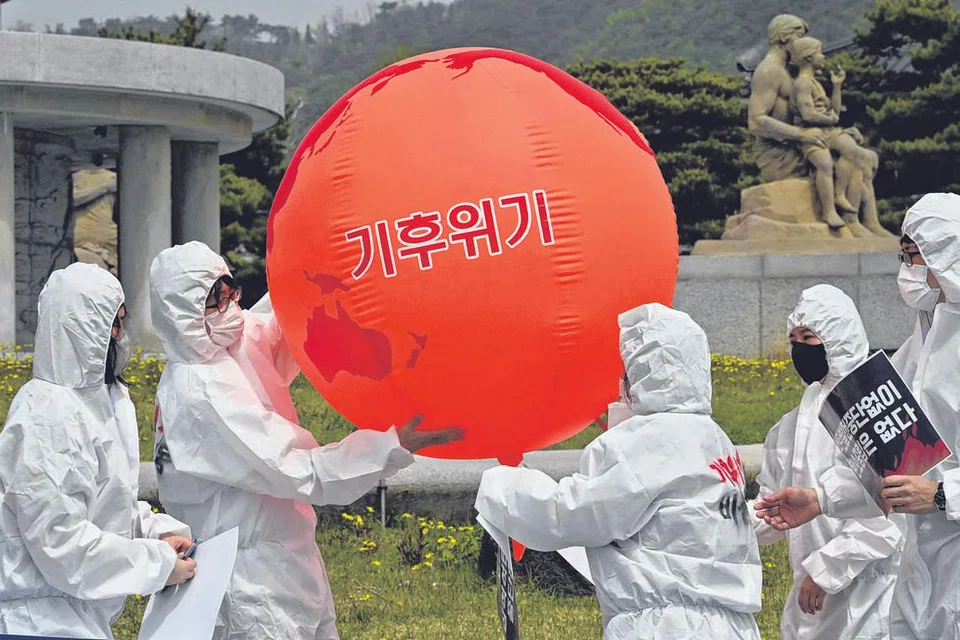 USAHA ANAK ALAM: Sekumpulan pencinta alam mengambil bahagian dalam rapat sempena Hari Bumi pada 22 April lalu bagi membantah berlakunya perubahan iklim berdekatan istana presiden di Seoul, Korea Selatan. - Foto AFP