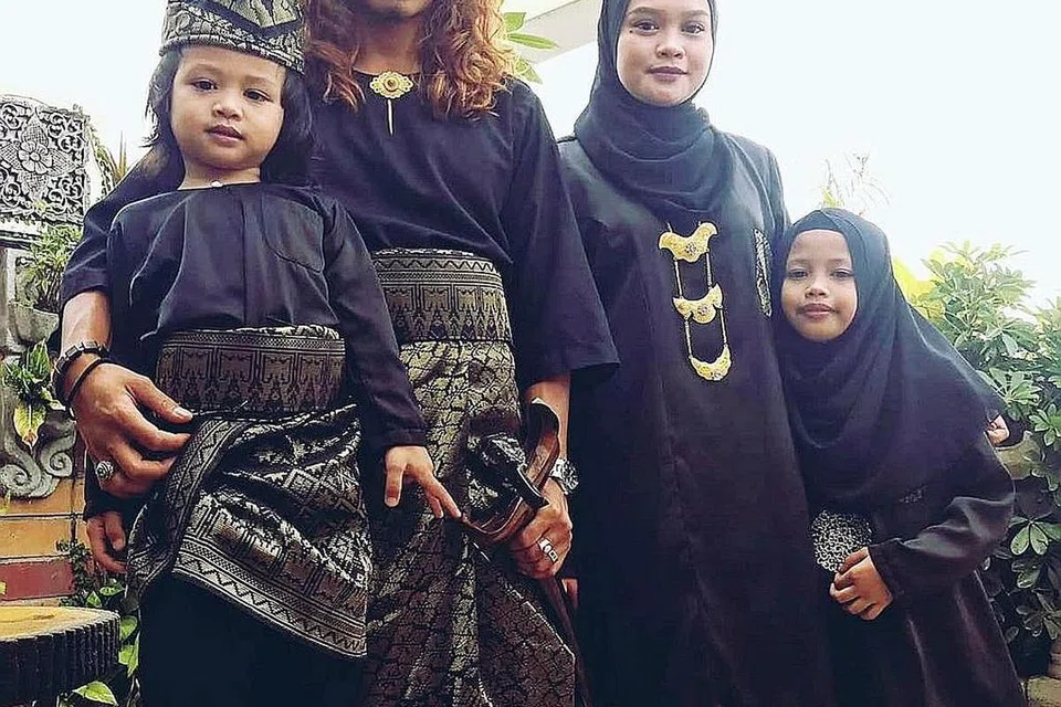 BERGAYA DENGAN TANJAK: Encik Abdul Walid Moehtar bersama keluarga termasuk anak lelakinya, menarik perhatian ramai apabila bertanjak semasa berjalan Raya. - Foto BM ihsan ABDUL WALID MOEHTAR