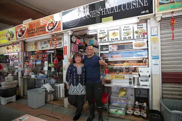 RAIH MANFAAT DIGITAL: Pemilik gerai Annie's Halal Cuisine, Cik Muliani dan suaminya Encik Sawal telah menawarkan kaedah pembayaran elektronik sejak lebih setahun lalu. - Foto BH oleh GIN TAY