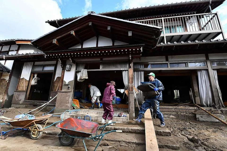 BERSIHKAN KAWASAN TERJEJAS: Penduduk membersihkan barang-barang yang terjejas di rumah mereka yang dipukul badai Hagibis. - Foto AFP 