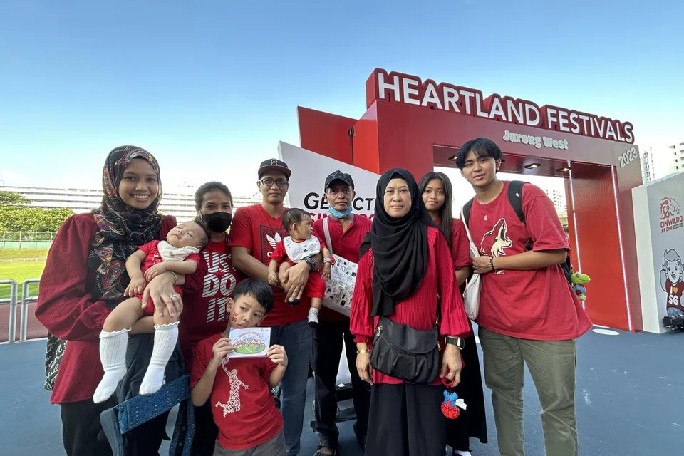 SEKELUARGA BERPESTA: Cik Fanduriyah Ismail (tiga dari kanan) bersama suami, anak dan cucunya, berkumpulan di Stadium Jurong West pada Sabtu untuk menyertai Pesta Kejiranan GetActive yang diadakan sempena sambutan Hari Kebangsaan.