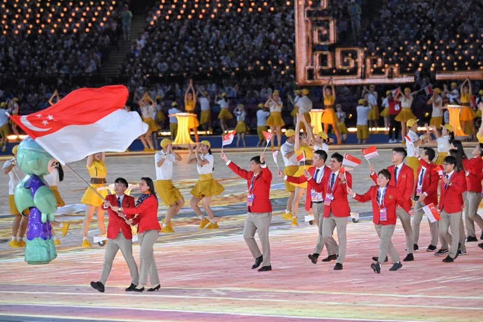 BANGGA: Kontinjen Singapura, yang dipimpin pembawa bendera Jowen Lim (kiri) dan Amita Berthier (kanan), berarak di majlis pembukaan Sukan Asia Hangzhou. 