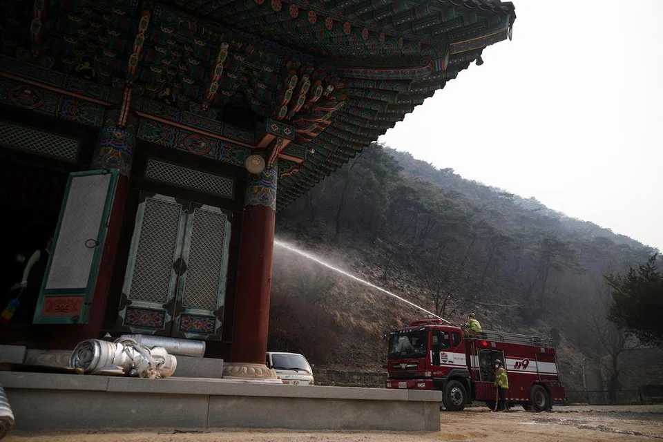 Anggota bomba bertungkus lumus bekerja di kuil Gounsa yang musnah akibat kebakaran hutan di Uiseong, Korea Selatan, 27 Mac 2025