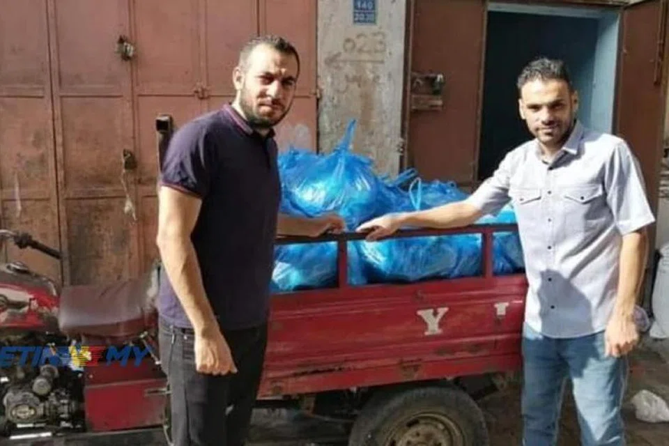 TINGGAL KENANGAN: Suami Cik Nurul Ain, Encik Mohd Adnan Shaat, 33 tahun (kiri), bersama pemilik stor, Encik Abu Faiq, sekitar Oktober lalu. Stor barangan milik Encik Abu Faiq musnah dibom Israel pada 6 Disember lalu menyebabkan bapa saudaranya turut terbunuh. 