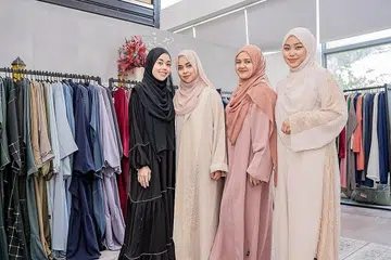 DEMI WANITA: Ustazah Liyana Musfirah (kanan) bergabung dengan pemilik syarikat fesyen baju tempatan, By Marlena, untuk menghasilkan rekaan baju abaya khas, yang hasil kemudian disalurkan untuk membiayai kos terapi kaum wanita yang memerlukan tetapi kurang berkemampuan. Pemilik By Marlena termasuk (dari kiri) Cik Siti 'Ainul Mardhiah Herman, Cik Nur Amalia Nazura Herman dan Cik Marlena Nasir. - Foto BH oleh NUR DIYANA TAHA
