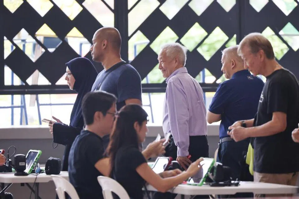 KUNJUNGI PUSAT UNDI: Encik Ng Kok Song (tengah) melawat pusat mengundi di Wisma Geylang Serai pada Jumaat.