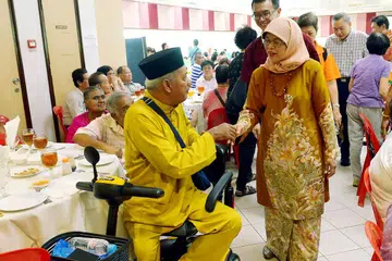 MERIAH RAYA BERSAMA: Cik Halimah Yacob berinteraksi dengan Encik Omar Ismail semasa acara sambutan Hari Raya beramai-ramai di Kelab Masyarakat Marsiling. - Foto TUKIMAN WARJI