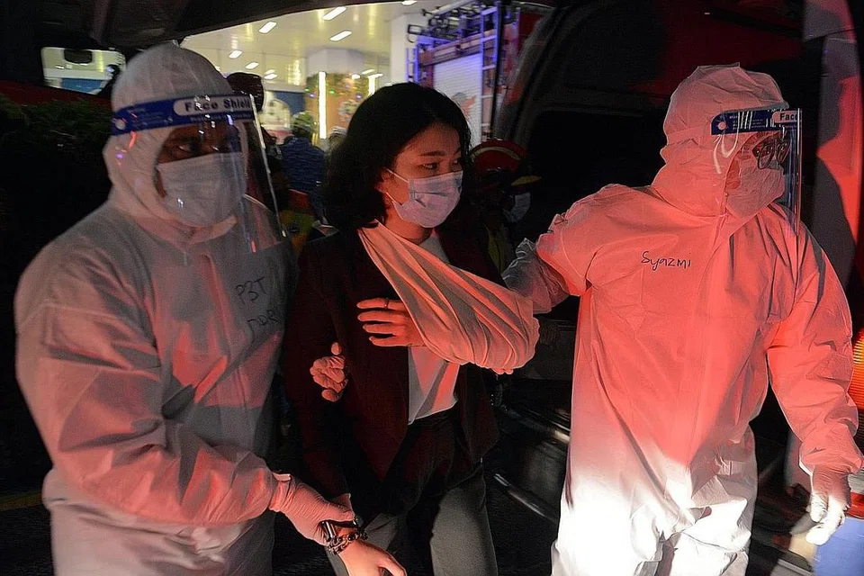 DIBERI BANTUAN: Anggota penyelamat memberi bantuan kepada seorang mangsa yang cedera di bahagian tangan di stesen KLCC selepas berlakunya kemalangan membabitkan dua tren LRT di laluan Kelana Jaya, Kuala Lumpur, malam kelmarin. - Foto EPA-EFE 