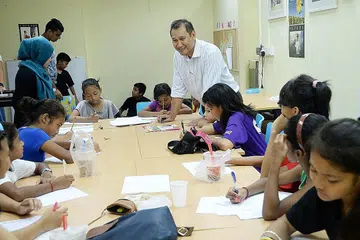 BIMBINGAN AKADEMIK: Antara program yang dijalankan Tasek Jurong Limited termasuk membimbing para pelajar dalam pendidikan. Menurut Encik Muhammad Faizal Othman (kemeja putih), pihaknya masih memerlukan sukarelawan untuk mengajar tuisyen kepada pelajar ini. - Foto-foto JOHARI RAHMAT