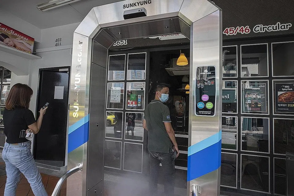 BASMI KUMAN: Seorang lelaki berjalan melalui mesin nyah kuman yang dipasang di pintu masuk sebuah restoran sebagai antara langkah mencegah penularan Covid-19 di Singapura. - Foto EPA-EFE