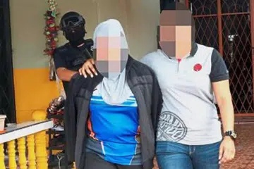KEGIATAN MILITAN: Pegawai imigresen wanita (kiri) yang ditahan di Lapangan Terbang Sandakan kerana menerima bayaran bagi membantu menjamin laluan selamat untuk anggota militan dari Indonesia dan Filipina. - Foto THE STAR