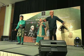 MENGUBAT RINDU PEMINAT: Penyanyi kegemaran ramai, Sanisah Huri (tengah) beraksi dengan penyanyi utama kumpulan Exists, Ezad Lazim (kiri); dan Man Bai penyanyi utama kumpulan Gersang dalam acara Hi-Tea Bintang-Bintang Berhari Raya baru-baru ini. - Foto BH oleh ISMAWATI ISMAIL